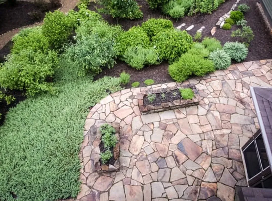 Aerial view of a landscaped garden with stone patio and planted beds