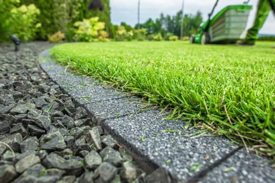 Close-up of a lush green lawn with a crisp edge along a stone border